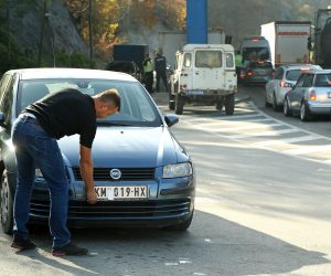 epa10279186 A motorist takes off stickers covering the national markings on his car license plates at the Jarinje border crossing between Kosovo and Serbia at Jarinje, Serbia, 01 November 2022. The Government of Kosovo will begin implementing a plan to eliminate the usage of Serbian car license plates. All owners of vehicles with Serbian number plates are warned and requested to visit any of the Vehicle Registration Centers and register their vehicles with RKS license plates. In the Serbian community of Kosovo, the RKS license plates are seen as unacceptable as they suggest the recognition of independence of the Republic of Kosovo.  EPA/DJORDJE SAVIC