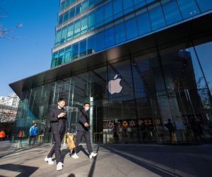 epa10291970 People wearing face masks walk past an Apple store at a mall in Beijing, China, 07 November 2022. China's Foxconn iPhone facotry in Zhengzhou was working to resume its production that had been hit by COVID-19 curbs, according to a company statement released on 07 November.  EPA/WU HAO