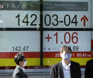 epa10299185 Pedestrians walk past a display showing the foreign exchange rate between the Japanese yen and US dollar in Tokyo, Japan, 11 November 2022. The Tokyo stock benchmark rose more than 750 points after the Wall Street surged in concern over the US Federal Reserve's interest rate hikes. The Japanese yen has risen from 146 low level on 10 November to 141 higher level.  EPA/KIMIMASA MAYAMA