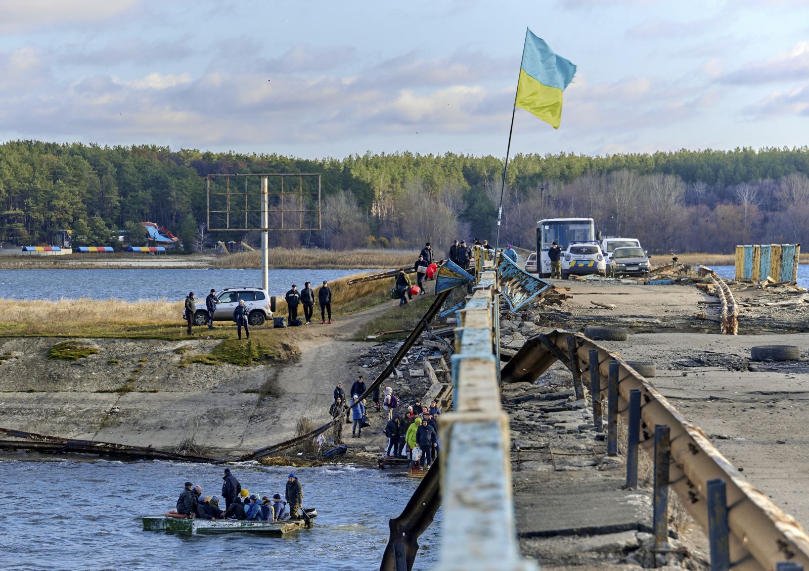 epa10304238 Locals use a boat to cross a reservoir next to a bridge that was destroyed by shelling in the recaptured settlement Staryi Saltiv near Kharkiv, Ukraine, 13 November 2022. At the beginning of September, Ukrainian forces recaptured the occupied territory following Russian troops' withdrawal form the northeast of the country. Kharkiv and surrounding areas have been the target of heavy shelling since February 2022, when Russian troops entered Ukraine starting a conflict that has provoked destruction and a humanitarian crisis.  EPA/SERGEY KOZLOV