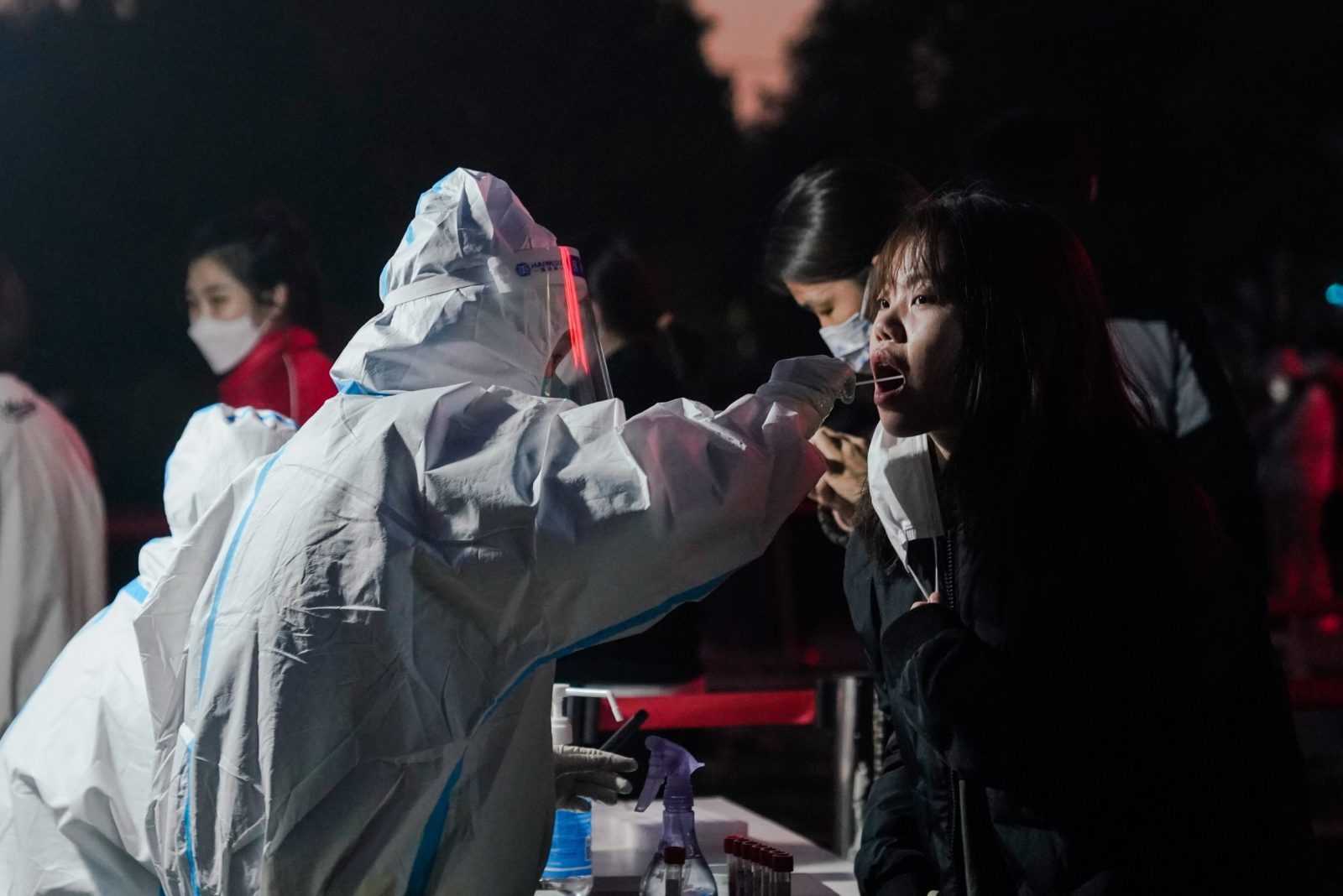 epa10305083 A woman undergoes a swab test to detect COVID-19 at a makeshift testing site in Chaoyang district in Beijing, China, 14 November 2022. According to the National Health Commission report on 14 November, little over 70 new locally transmitted COVID-19 cases were detected in the Chaoyang district in Beijing. The population is currently required to present a negative PCR test result taken within 24 hours in order to enter public venues like restaurants and shopping malls.  EPA/WU HAO