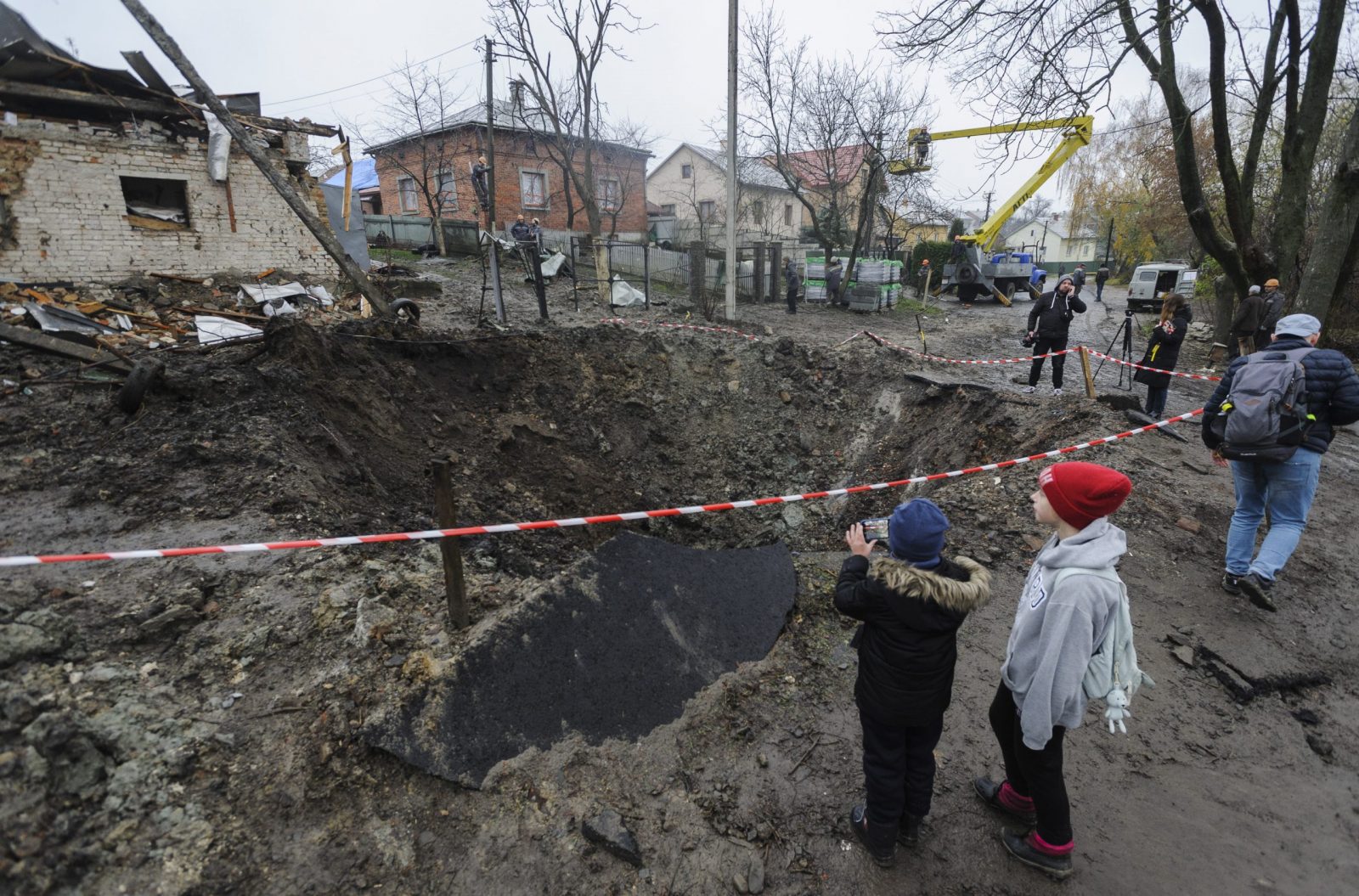 epa10308995 Locals look at the shelling hole after a recent rocket attack in the village of Solonka not far from the Western Ukrainian city of Lviv, Ukraine, 16 November 2022, amid the Russian invasion. Russia, on 15 November fired more than 90 missiles toward Ukraine, 70 of which were shot down by Ukrainian air defense, although at least 15 energy infrastructure facilities were damaged, leaving more than 7 million people without electricity, according to Deputy Head of the President's Office Kyrylo Tymoshenko.  EPA/MYKOLA TYS