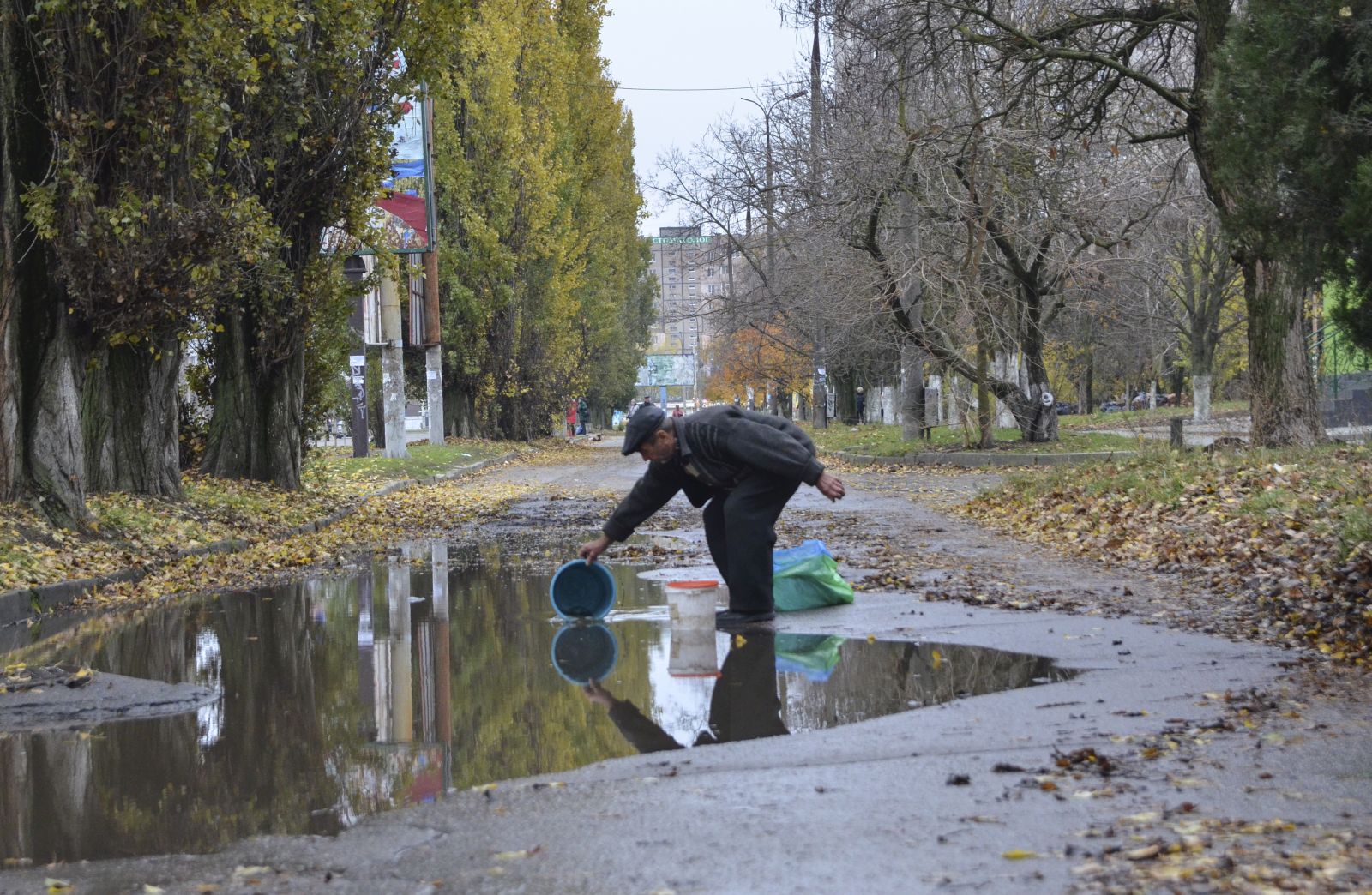 epaselect epa10313304 A local man collects water from a puddle in the city of Kherson, Ukraine, 18 November 2022. Ukrainian troops entered Kherson on 11 November after Russian troops had withdrawn from the city. Kherson was captured in the early stage of the conflict, shortly after Russian troops had entered Ukraine in February 2022.  EPA/IVAN ANTYPENKO
