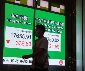 epa10317390 A man walks past an electronic billboard showing the Hang Seng Index closing figure in Hong Kong, China, 21 November 2022. The index dropped 1.9 at the end of trading day, the biggest setback in two weeks.  EPA/JEROME FAVRE