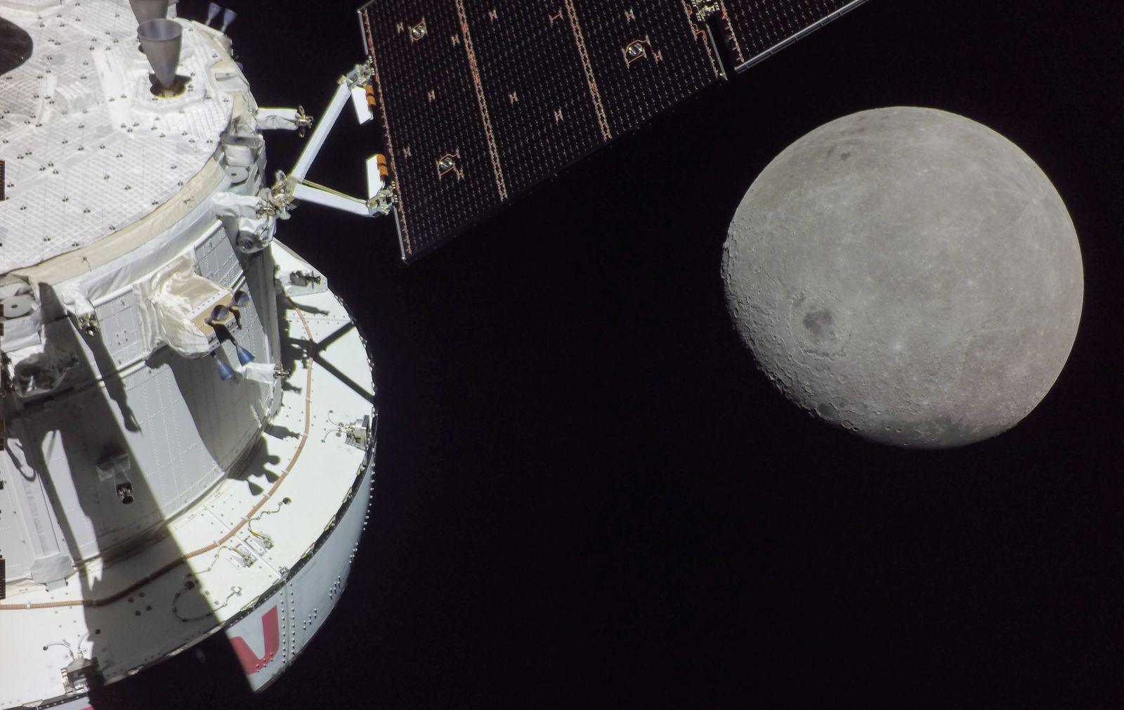 epa10320024 A handout photo made available by the NASA shows a portion of the far side of the Moon looms large just beyond the Orion spacecraft in this image taken on the sixth day of the Artemis I mission by a camera on the tip of one of Orion's solar arrays on 21 November 2022 (issued 22 November 2022). The spacecraft entered the lunar sphere of influence on 20 November making the Moon instead of Earth the main gravitational force acting on the spacecraft On 21 November iit came within 80 miles of the lunar surface the closest approach of the uncrewed Artemis I mission before moving into a distant retrograde orbit around the Moon. The darkest spot visible near the middle of the image is Mare Orientale.  EPA/NASA HANDOUT  HANDOUT EDITORIAL USE ONLY/NO SALES