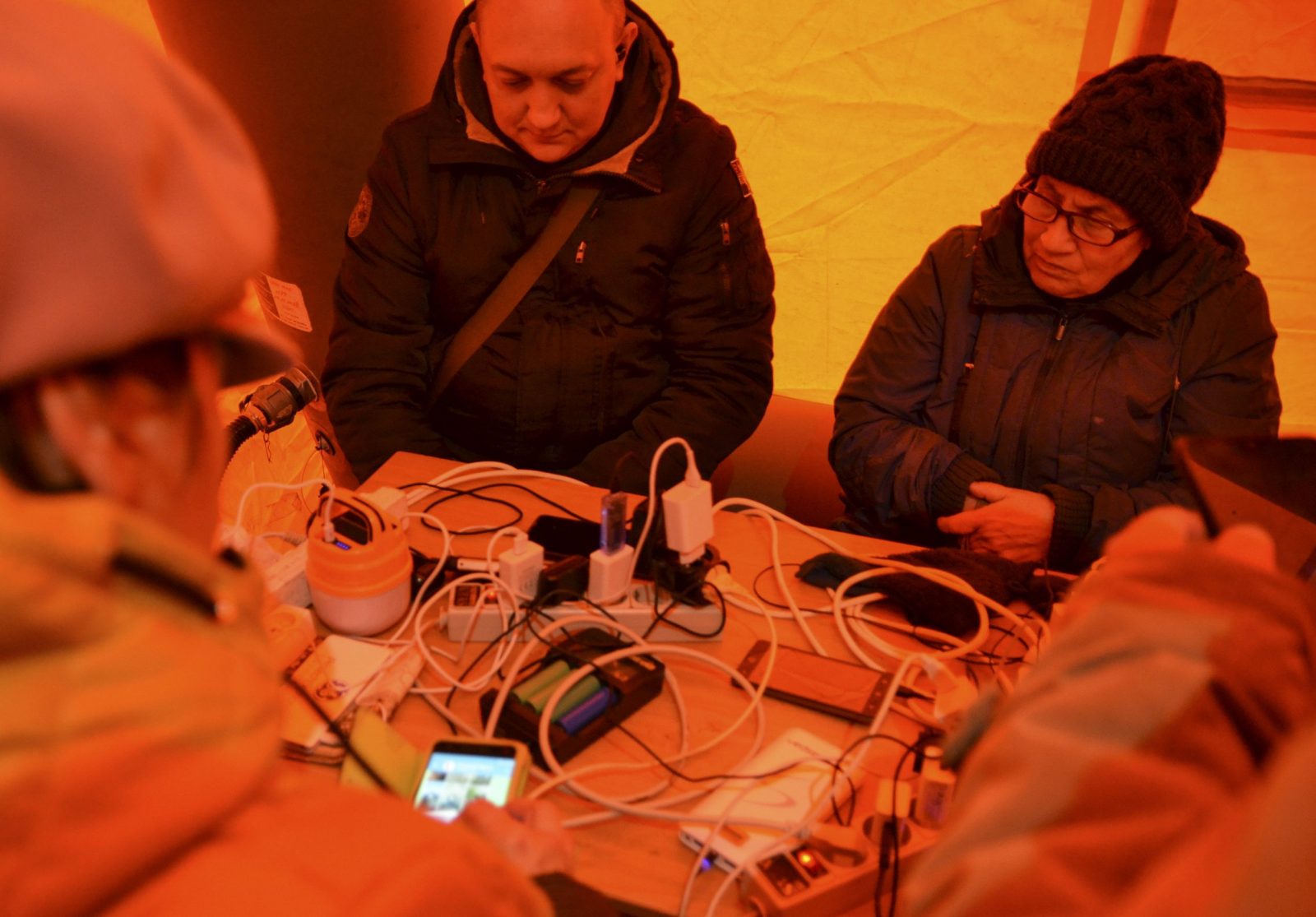 epa10321223 Locals sit at a table inside a tent while charging their mobile phones, in Kherson, southern Ukraine, 22 November 2022, amid Russia's invasion. Tents with heat, electricity, food and internet access have appeared in the recently recaptured Ukrainian city of Kherson, which is without electricity. The Ukrainian army is pushing Russian troops from occupied territory in the south of the country in counterattacks. Russian troops entered Ukraine on 24 February 2022 starting a conflict that has provoked destruction and a humanitarian crisis.  EPA/IVAN ANTYPENKO