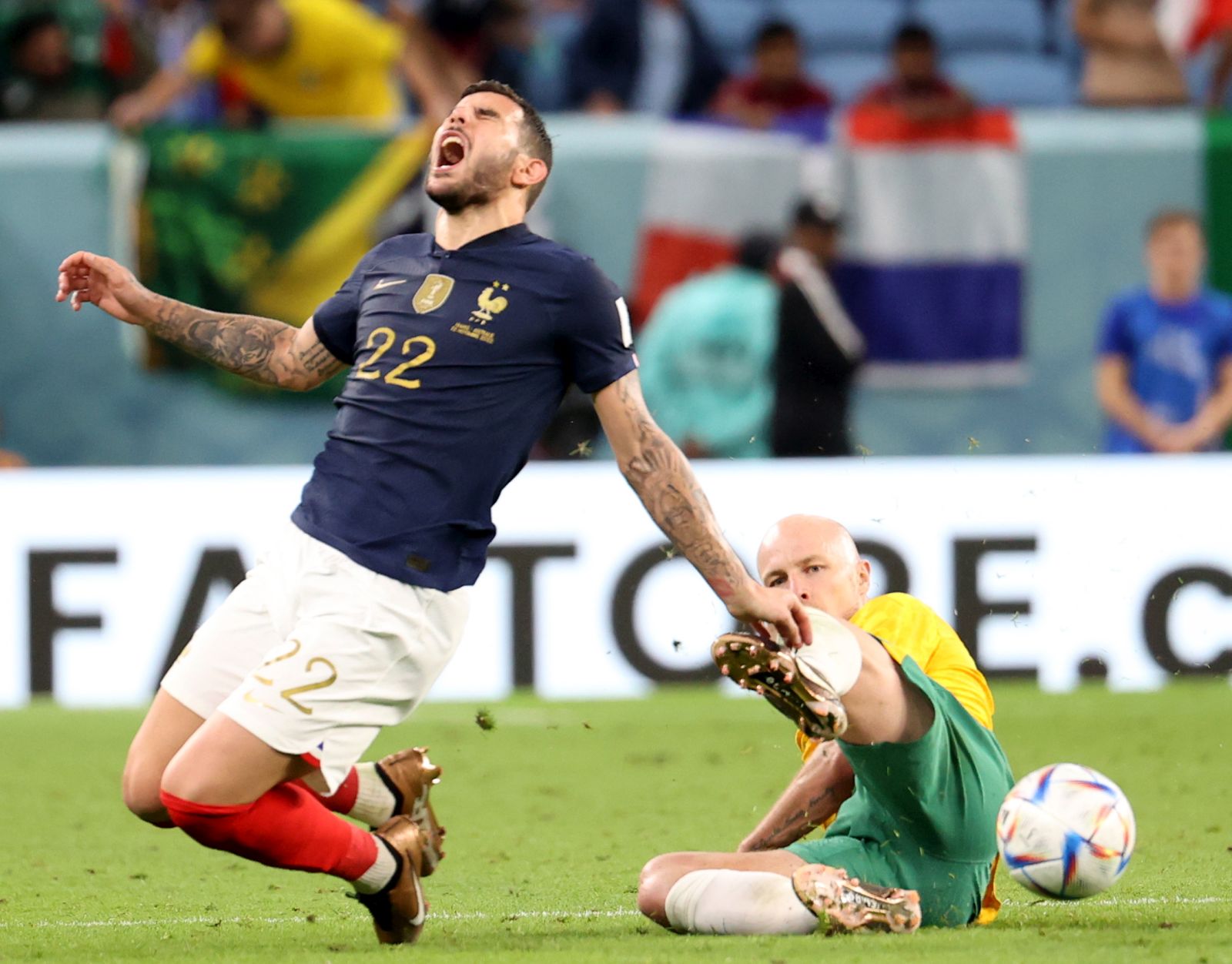 epa10321483 Theo Hernandez (L) of France in action against Aaron Mooy of Australia during the FIFA World Cup 2022 group D soccer match between France and Australia at Al Janoub Stadium in Al Wakrah, Qatar, 22 November 2022.  EPA/Abedin Taherkenareh