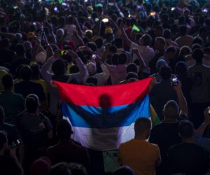 epaselect epa10326132 A fan holds the Serbian flag as people watch the FIFA World Cup Qatar 2022 match between Brazil and Serbia at the Fan Festival in the centre of Doha, Qatar, 24 November 2022.  EPA/MARTIN DIVISEK