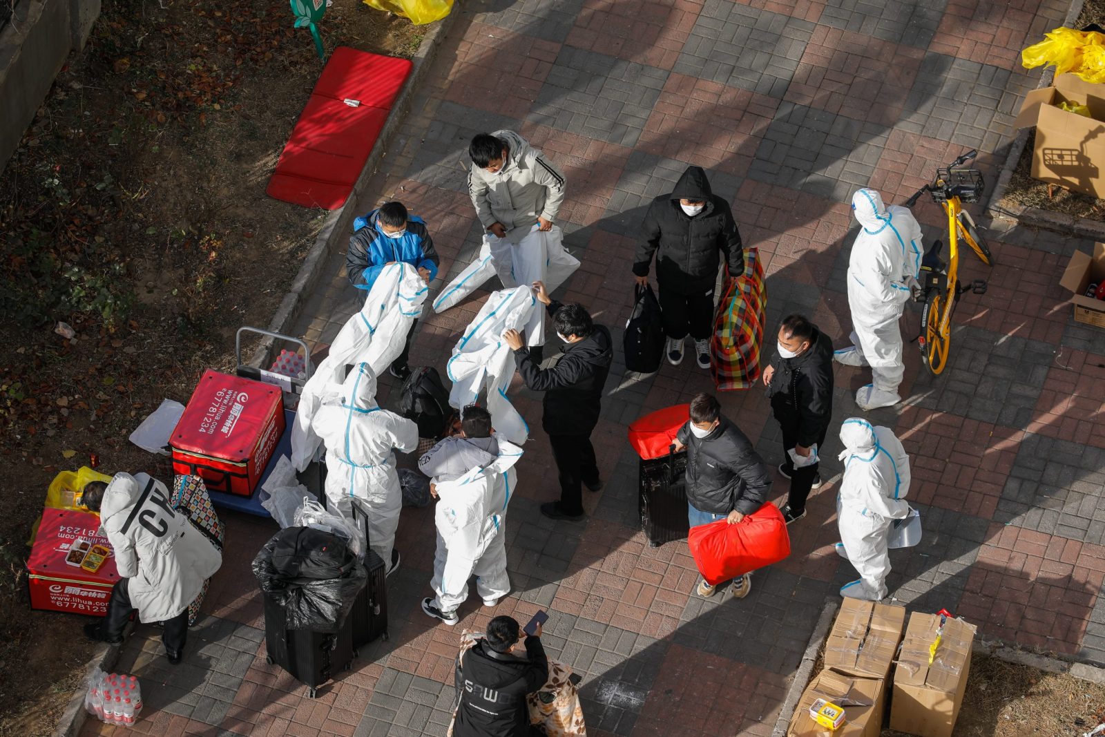 epa10326874 Volunteer health workers wear protective clothing outside of a Unit building with confirmed case in Beijing, China, 25 November 2022. According to the National Health Commission report on 25 November, over 1000 new locally transmitted COVID-19 cases were detected in Beijing, stricter COVID-19 prevention measures have been implemented by the local government and many communities with confirmed cases have been blocked.  EPA/WU HAO