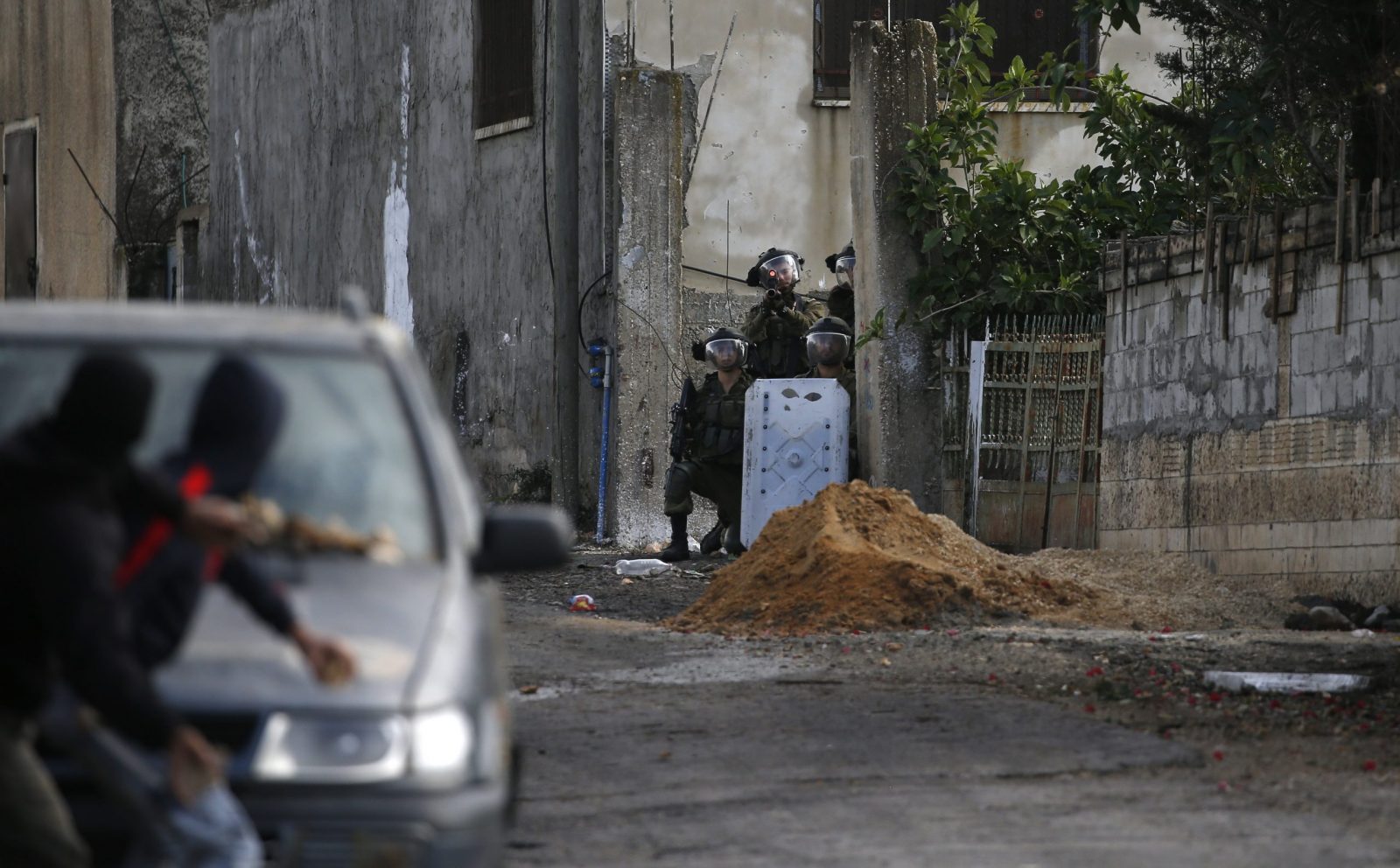 epa10327569 Palestinian protesters throw stones at Israeli troops during clashes after a demonstration against Israel's settlements on the lands of Kafr Qadoum village, near the West Bank city of Nablus, 25 November 2022.  EPA/ALAA BADARNEH