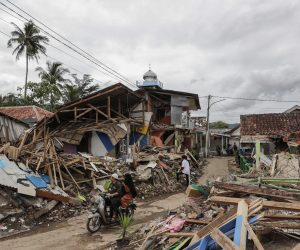 epa10329366 Motorists ride past collapsed houses affected by the 5.6 magnitude earthquake in Cianjur, West Java, Indonesia, 26 November 2022. According to the National Disaster Management Authority (BNPB), at least 310 people killed and 24 missing after 5.6 magnitude earthquake hit southwest of Cianjur, West Java on 21 November 2022.  EPA/MAST IRHAM