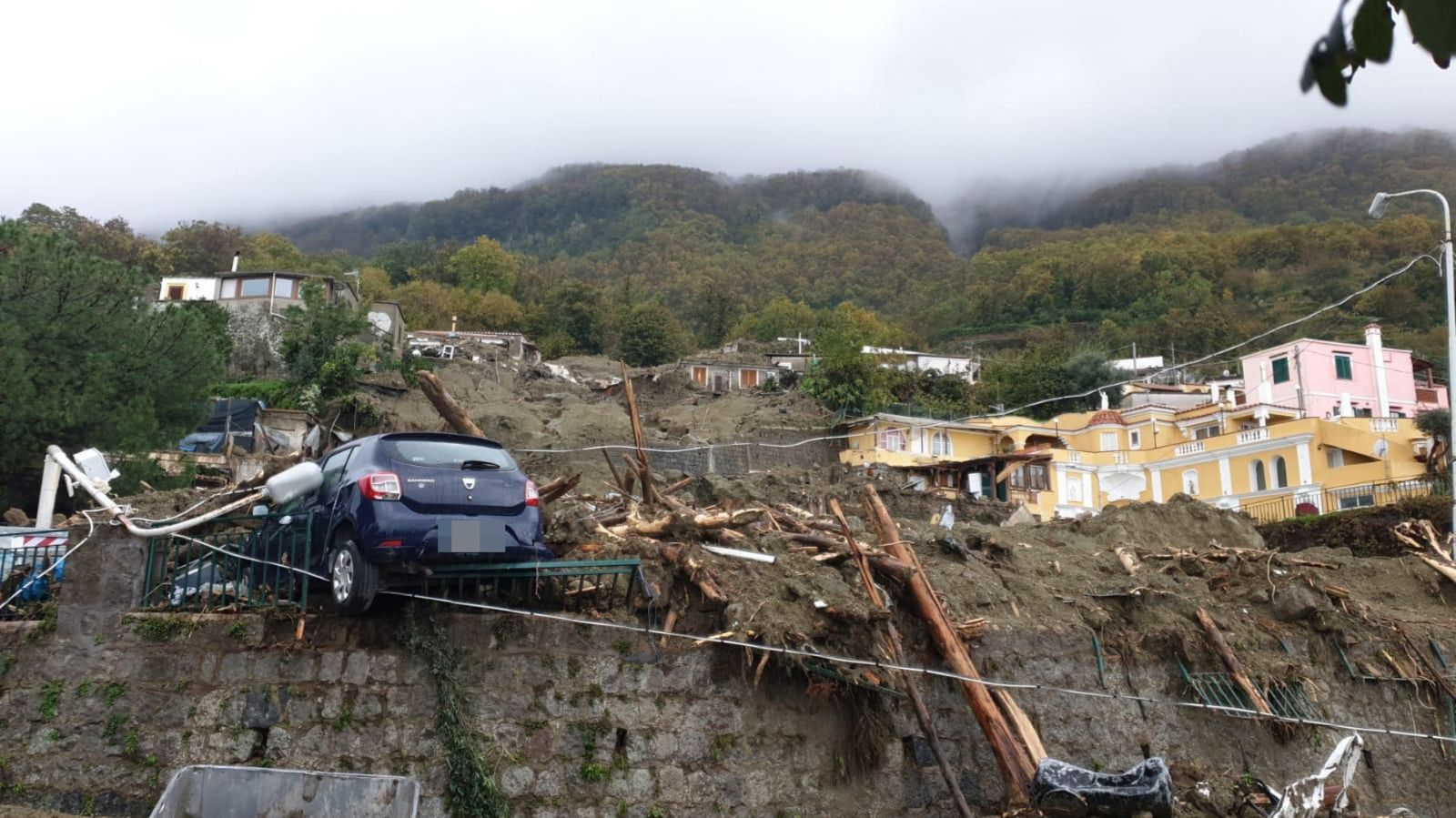 epa10331232 An area affected by a landslide in Ischia island, in the Gulf of Naples, Italy, 26 November 2022. A group of people are feared to be missing after heavy rain caused a landslide from the top of the Epomeo mountain, at a height of about 780 meters, and reached the seafront, overwhelming some parked cars and dragging them to the sea.  EPA/CIRO FUSCO ITALY OUT
