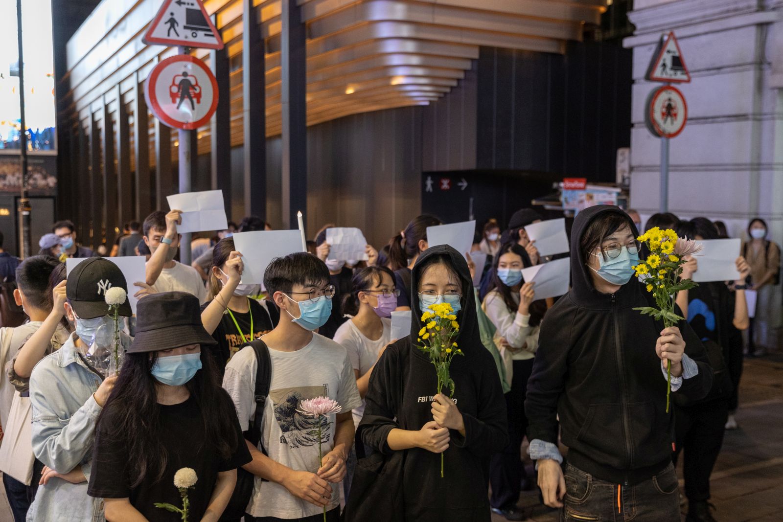 epa10334250 Mourners hold flowers during a vigil for the victims of China’s zero-COVID policy and the victims of the Urumqi fire in Hong Kong, China, 28 November 2022. Protests against China's strict COVID-19 restrictions have erupted in various cities including Beijing and Shanghai, triggered by a tower fire that killed 10 people in Xinjiang’s capital, Urumqi.  EPA/JEROME FAVRE