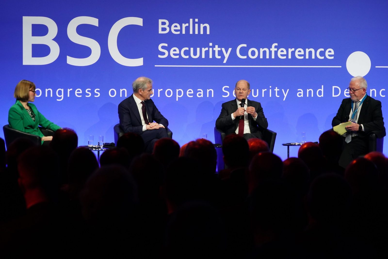 epa10339558 German Chancellor Olaf Scholz (3-R) speaks next to Norwegian Prime Minister Jonas Gahr Store (2-L), Editor and CDO Behoerden Spiegel Eva-Charlotte Proll (L) and BSC Congress President and Member of German Parliament Wolfgang Hellmich during the Berlin Security Conference (BSC) in Berlin, Germany, 30 November 2022. BSC connects experts from Germany and abroad to discuss matters of foreign policy, security and defense policy.  EPA/CLEMENS BILAN