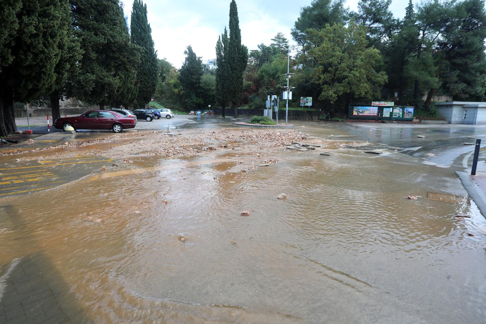 18.11.2022., Malinska - Vodena bujica slijeva se kroz centar Malinske prema moru. Gradjani uklanjaju posljedice poplave koju je izazvala jaka kisa u jutarnjim satima. . Photo: Goran Kovacic/PIXSELL
