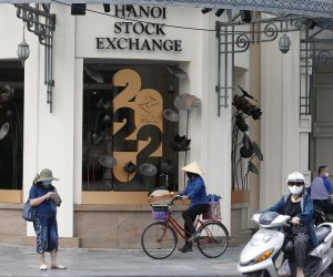 epa10338076 A woman rides bicycle past Hanoi's Stock Exchange, in Hanoi, Vietnam, 30 November 2022. The Vietnamese stock market lost 20.2 billion USD in first half of this month. The market has recently showed positive signals to recover in the first session of this week, according to media reports.  EPA/LUONG THAI LINH