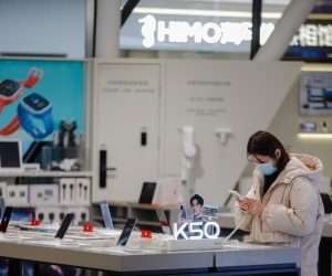 epa10341014 A woman wearing a face mask uses a cellphone at Raffles city shopping mall in Beijing, China, 01 December 2022. Many shopping malls in Beijing, including Raffles City and Shunyi Longhua Outlets Shopping Plaza, announced the reopening of the malls from 01 December 2022, with a negative PCR test result taken within 48 hours for customers to enter.  EPA/WU HAO