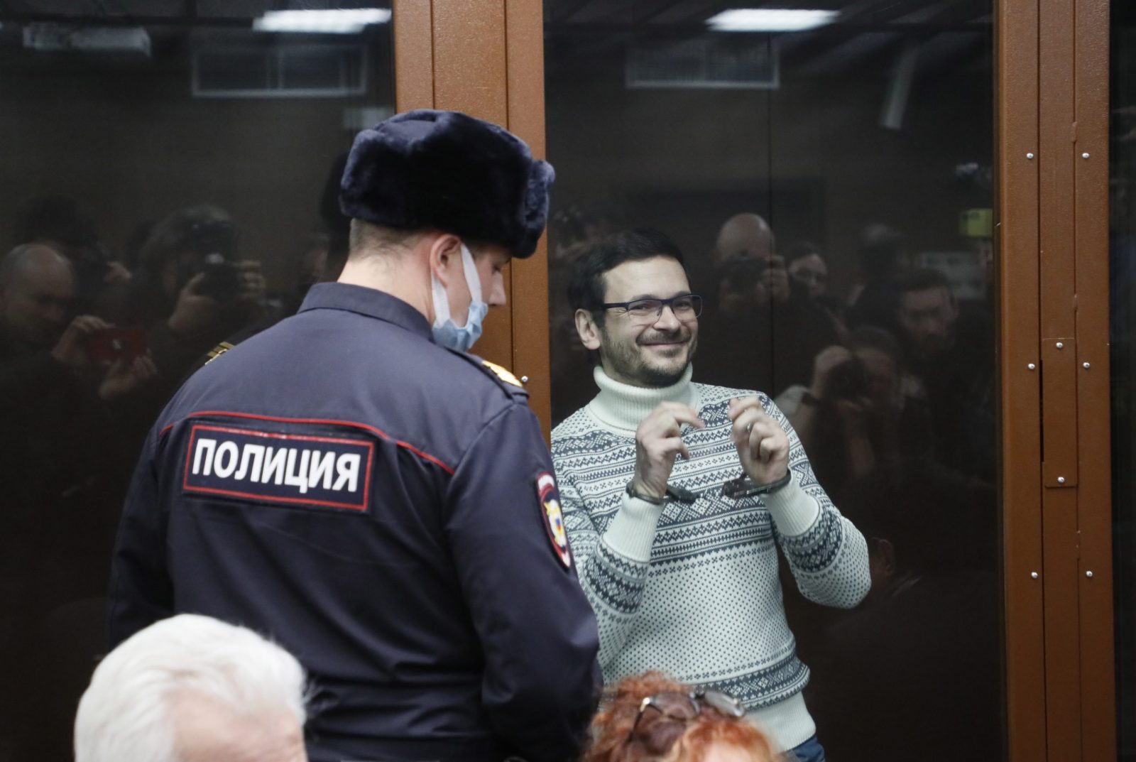 epa10356385 Russian opposition leader, former Moscow's municipal deputy Ilya Yashin (R) stands inside a defendant's cage prior to a verdict hearing at the Meshchansky district court in Moscow, Russia, 09 December 2022. The prosecution requested nine years in prison for Ilya Yashin for spreading 'fake information' about the Russian army.  EPA/YURI KOCHETKOV / POOL