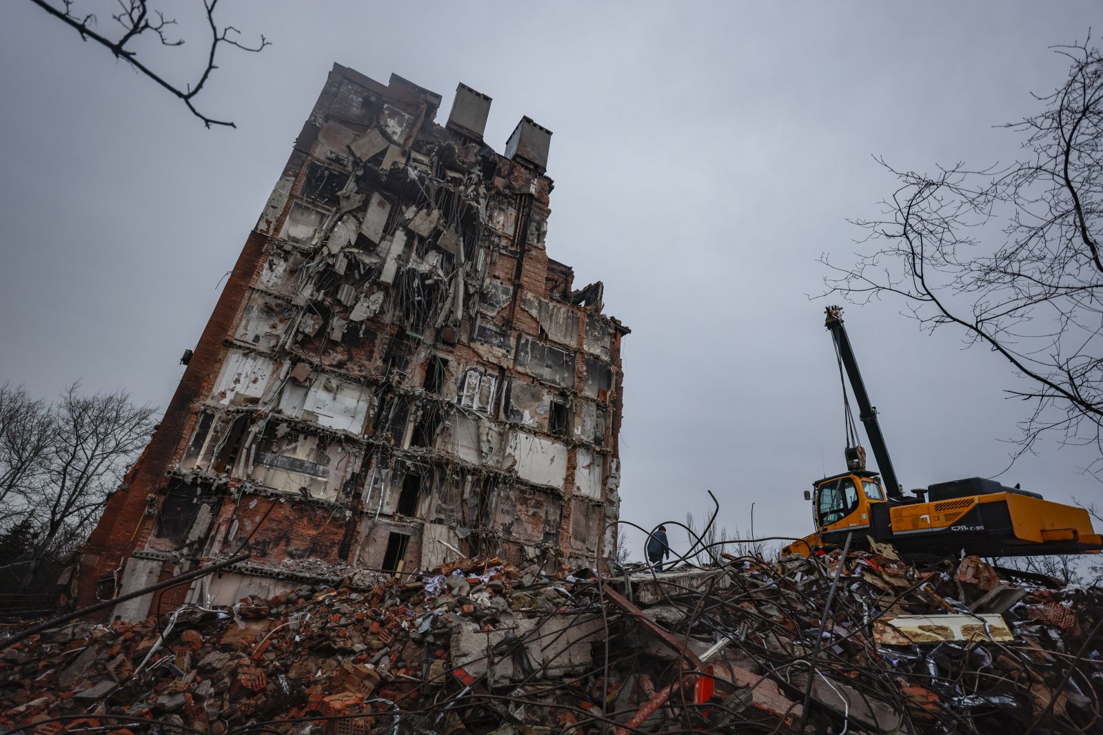 epa10362466 A man walks on the debris of destroyed building in downtown Mariupol, Ukraine, 12 December 2022. Mariupol had seen a long battle for its control between the Ukrainian forces and the Russian army and Russian backed separatist Donetsk People’s Republic (DPR) as well as a siege, the hostilities lasted from February to the end of May 2022 killing thousands of people and destroying most of the city in the process. According to the DPR government which took control after May 2022, more than five thousand builders are currently working in Mariupol, they expect the city to be completely rebuilt in three years' time.  EPA/SERGEI ILNITSKY