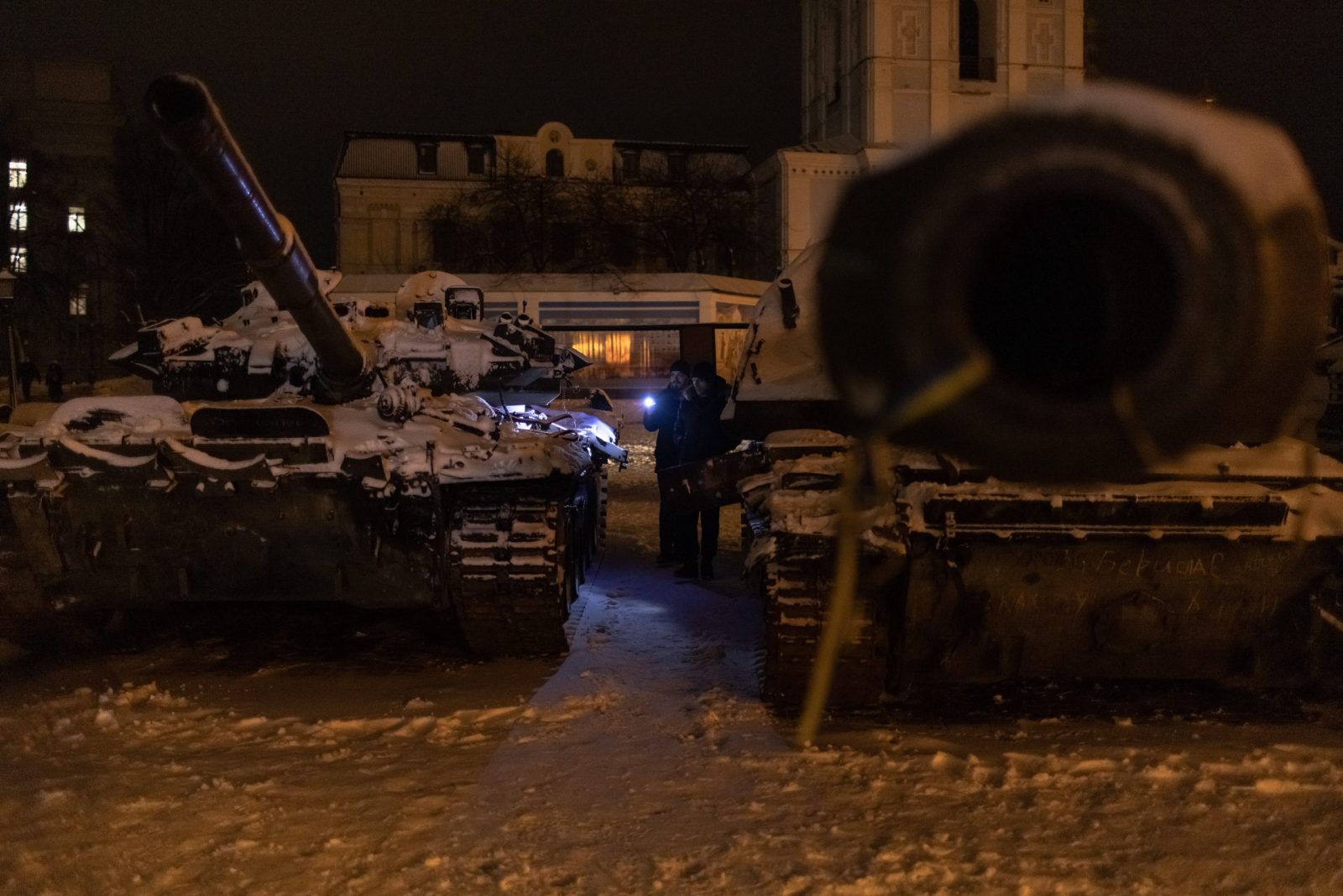 epa10367523 Men look at Russian tanks destroyed in fights with the Ukrainian army, displayed in Mykhailivskyi Square, in Kyiv, Ukraine, 15 December 2022. Russian troops on 24 February entered Ukrainian territory, starting a conflict that has provoked destruction and a humanitarian crisis.  EPA/ROMAN PILIPEY