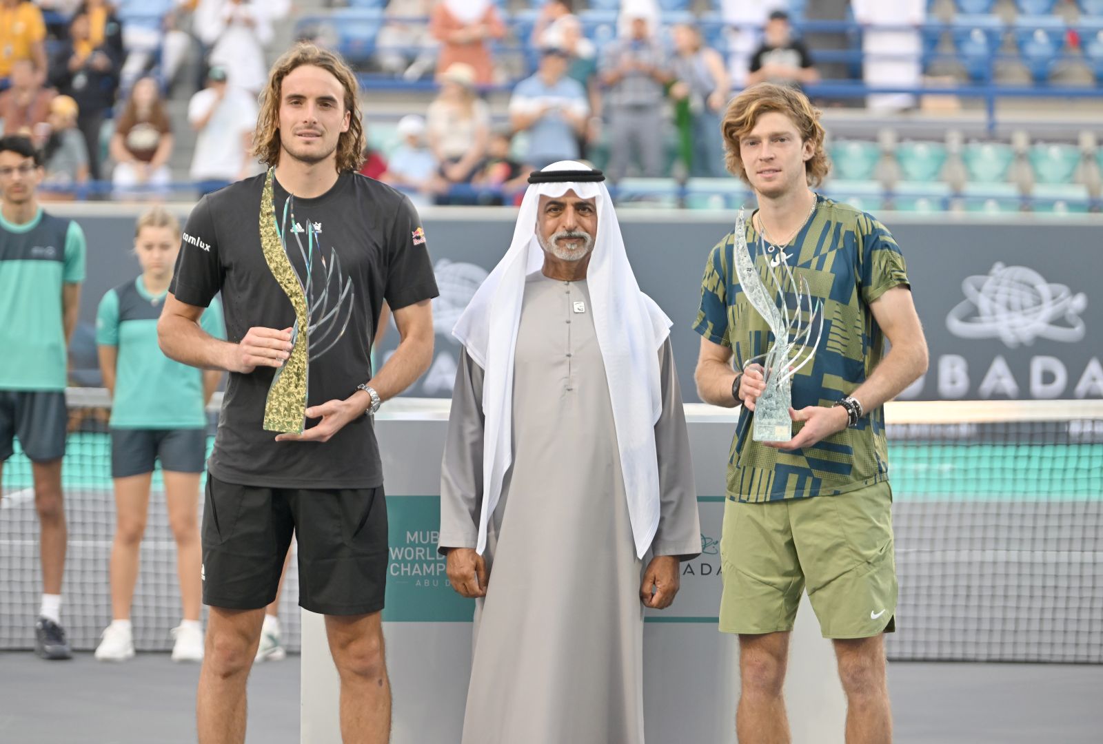 epa10371889 Winner Stephanos Tsitsipas of Greece (L) and runner up Andrey Rublev of Russia (R) with H.E. Sheikh Nahya Bin Mubarak Al Nahyan (C) after the Men’s Championship Match at the Mubadala World Tennis Championship exhibition tournament in Abu Dhabi, United Arab Emirates, 18 December 2022.  EPA/STR