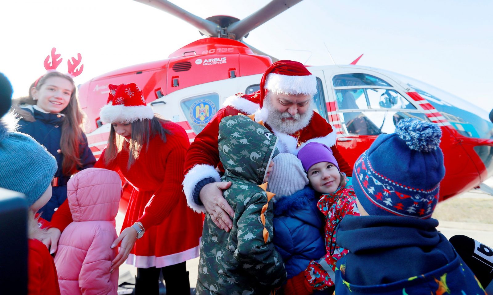 epa10374836 A Santa and his helper, who just landed with an emergency rescue helicopter, are welcomed by children before they attend a Christmas Tree show dedicated to the children of emergency rescue staff at the Interior Ministry Aviation Center in Bucharest, Romania, 20 December 2022. Children of firefighters, emergency rescuers, pilots and other staff of the Romanian Ministry of the Interior (MAI) received gifts from Santa at an event organized in the hangar that houses the helicopters, after Santa was dropped at the location by a rescue helicopter. Romania, an Orthodox Christian country, celebrates Christmas on 25 December. SMURD is an emergency rescue service based in Romania (Mobile Emergency Service for Resuscitation and Extrication), created in 1990.  EPA/ROBERT GHEMENT