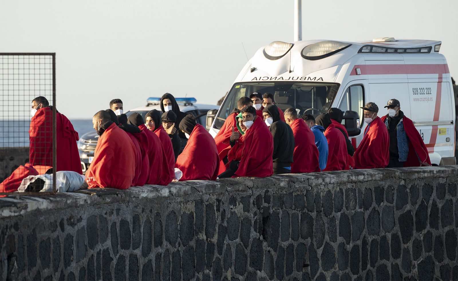 epaselect epa10375471 A group of migrants rest in the port of Arrecife after being rescued by the Spanish Maritime Safety and Rescue Society in the waters of northern Lanzarote, Spain, 21 December 2022. The 77 migrants, including four women and two children, tried to enter the Canary Islands aboard two small boats.  EPA/ADRIEL PERDOMO