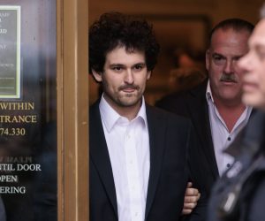 epa10376656 Cryptocurrency entrepreneur Sam Bankman-Fried (C) is lead out of an U.S. Federal Courthouse after being released on bail following an arraignment in New York, New York, USA, 22 December 2022. Bankman-Fried,  who was extradited to the U.S. from the Bahamas yesterday, is facing federal charges that he used money from investors illegally for personal gain.  EPA/JUSTIN LANE
