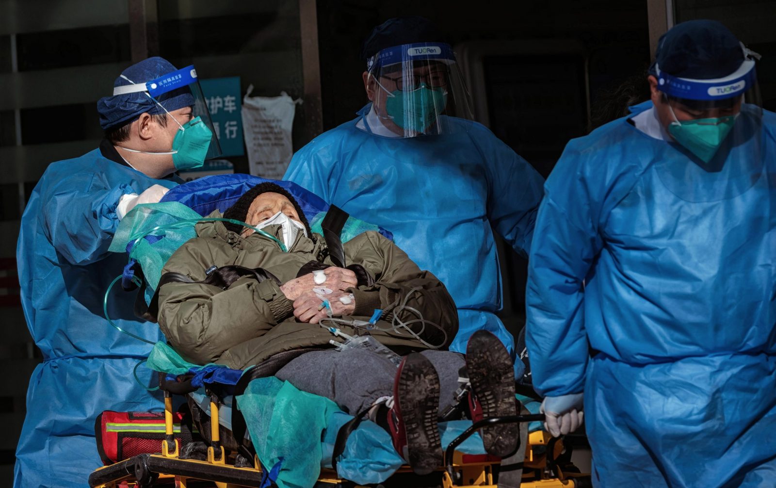 epa10376985 Health workers carry a person to the hospital, in Shanghai, China, 23 December 2022. Hospitals in China struggle to cope due to the rising number of COVID-19 cases. Since the abrupt lifting of domestic COVID-19 restrictions, cases have rocketed in China, causing businesses to close because employees are sick, schools are shifting to online classes, and pharmacies are struggling with the high demand. On 21 December, Shanghai Deji Hospital’s official WeChat account published a post with an estimated 5.43 million positive cases in the city and predicted that 12.5 million could get infected by the end of the year. The day after, the post was no longer available.  EPA/ALEX PLAVEVSKI