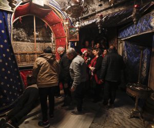 epa10377245 Christian pilgrims pray at the Grotto in the Church of Nativity ahead of Christmas, in Bethlehem, West Bank, 23 December 2022, Church of the Nativity is one of the oldest continuously operating churches worldwide. The structure is built over the cave that tradition marks as the birthplace of Christ, and it is considered sacred by followers of Christianity.  EPA/ATEF SAFADI