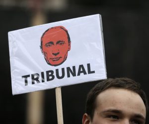 epaselect epa10377660 A protestor holds a banner depicting Russian President Vladimir Putin reading 'Tribunal' during a protest organized by the Russian Democratic Society in Serbia in Belgrade, Serbia, 24 December 2022. Russian troops entered Ukraine on 24 February 2022 starting a conflict that has provoked destruction and a humanitarian crisis.  EPA/ANDREJ CUKIC