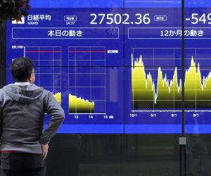 epa10368077 A passerby walks past a stock market indicator board in Tokyo, Japan, 16 December 2022. Tokyo stocks plunged to a one-month low following concerns over possible recession in the United States and Europe. The 225-issue Nikkei Stock Average lost 524.58 points, or 1.87 percent, to close at 27,527.12.  EPA/FRANCK ROBICHON