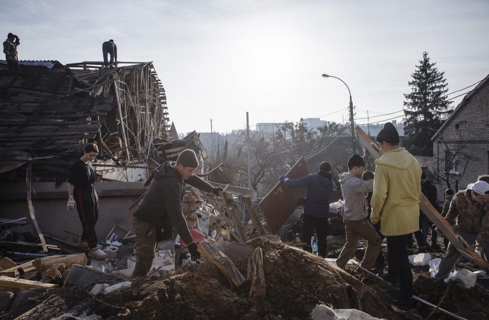 epa10387009 Volunteers clean debris at the site of a Russian missile attack that occured on 31 December 2022 in Kyiv, Ukraine, 03 January 2023. Russian missiles targeted major cities across Ukraine on 31 December prior to the New Year celebration. Russian troops entered Ukraine on 24 February 2022 starting a conflict that has provoked destruction and a humanitarian crisis.  EPA/MIKHAIL PALINCHAK