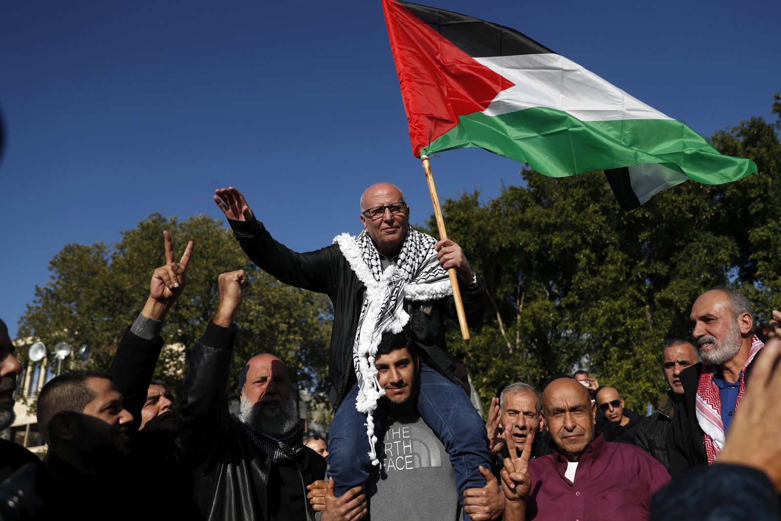 epa10390058 Israeli Arab prisoner Karim Younes (C), the longest consecutively-held inmate in Israeli jails, waves a Palestinian flag as he is carried on a family member's shoulders after being  released after 40 years, while being welcomed at his hometown of Ar'a, Israel, 05 January 2023. Karim Younes, 62, has been jailed since 06 January 1983, accused of the killing of Israeli soldier Avraham Bromberg in 1981. Younes initially was sentenced to death, the verdict was later changed into a 40-years prison term.  EPA/ATEF SAFADI