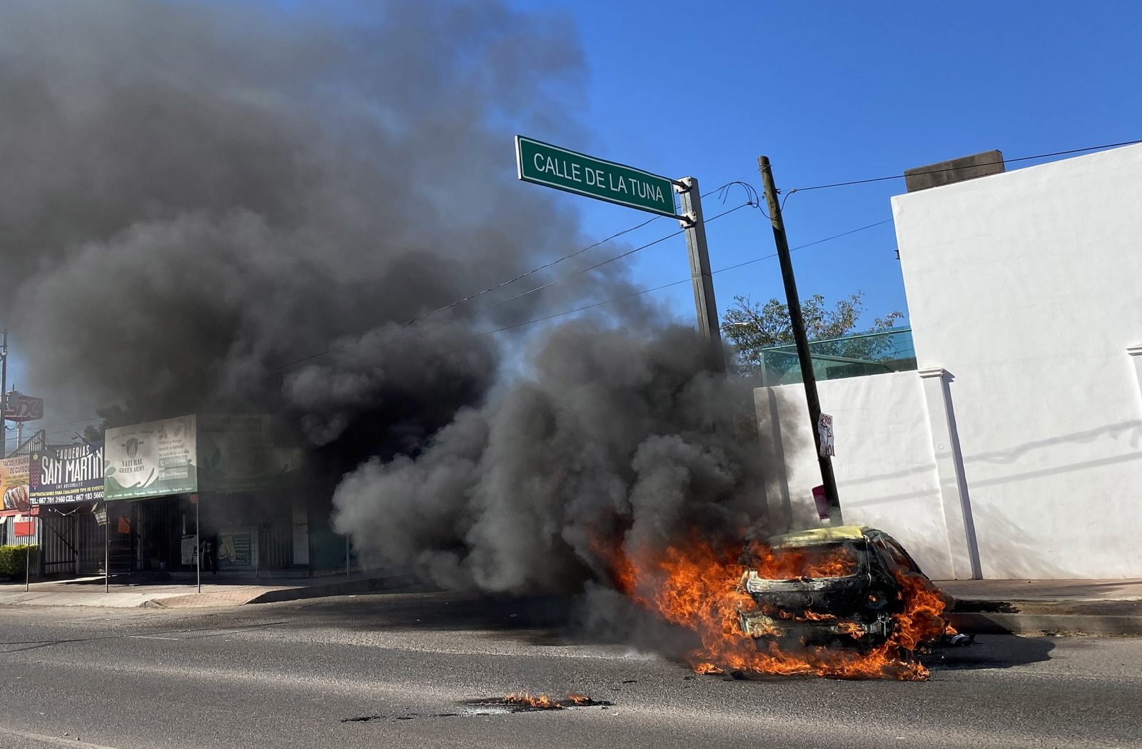 epa10390981 A burning vehicle in street after clashes between federal forces and armed groups, in the city of Culiacan, state of Sinaloa, Mexico 05 January 2023. The Mexican authorities captured Ovidio Guzman, one of the sons of Joaquin 'el Chapo' Guzman, most wanted by the US authorities, during an operation that unleashed fires, blockades and attacks in Culiacan, northern Mexico, according to federal government sources.  EPA/Juan Carlos Cruz