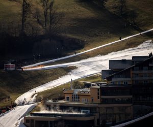 epa10392241 Skiers go downhill a slope in an otherwise snowless surrounding in Schladming, Austria, 06 January 2023. Countries across Europe have been experiencing record-breaking January temperatures, according to meteorologists. At least eight European countries have recorded their warmest January day ever.  EPA/Christian Bruna