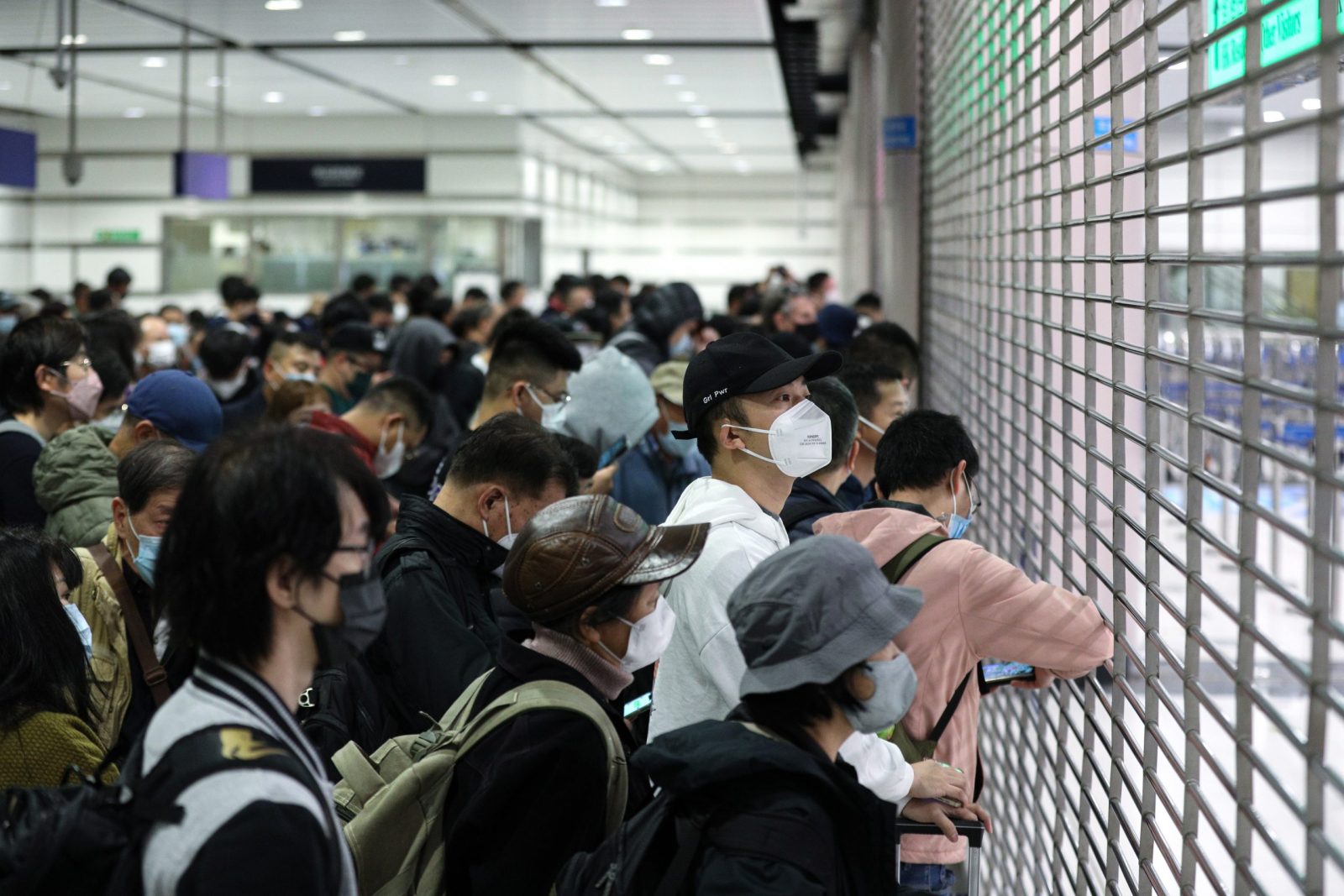 epa10394869 Travellers wait for the Hong Kong immigration desks to open before crossing the border to China at Lok Ma Chau MTR station, in Hong Kong, China, 08 January 2023. From 08 January 2023, after three years of closures due to Covid-19 pandemic restrictions, at least 60,000 people a day are allowed to cross the Hong Kong-mainland China border each way without the need to undergo quarantine. Seven land, sea and air cross-border checkpoints have returned to regular operating hours after three years of closures or limited services under some of the world's toughest and longest pandemic restrictions. A negative polymerase chain action (PCR) test result taken within the past 48 hours is still required to travel to either side of the Hong Kong-China border.  EPA/JEROME FAVRE