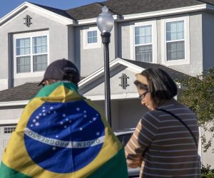 epa10401534 People stand in front of the house at the Encore Resort Homes, where former Brazil president Jair Bolsonaro is staying, in Reunion, Florida, USA, 12 January 2023. US Lawmakers called US President Joe Biden to extradite Bolsonaro back to his country from Florida. Bolsonaro has been staying in Central Florida, near Orlando, as his supporters protest in Brazil.  EPA/CRISTOBAL HERRERA-ULASHKEVICH