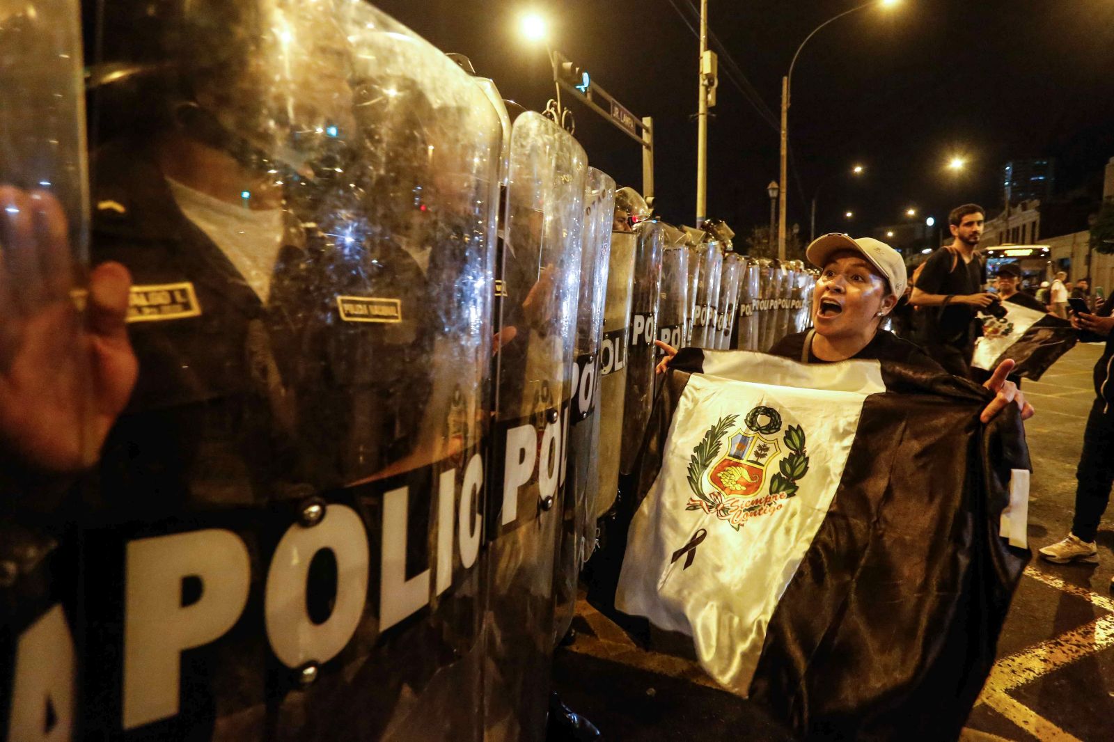 epa10402498 People protest in front of police during a new march against the Government of Dina Boluarte, in Lima, Peru, 12 January 2023. The call for an anti-government protest march this 12 January in Lima brought together hundreds of protesters from left and extreme left political parties, labor unions and civil groups who mobilized along the main avenues of the historic center.  EPA/Renato Pajuelo
