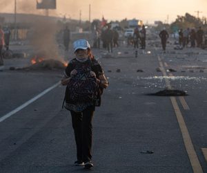 epa10402455 People cross the border on foot due to the blockades on the highway that connects the countries of Peru and Chile, in Tacna, Peru, 12 January 2023, during a new day of demonstrations to demand new general elections, the removal of President Dina Boluarte and justice for the protesters killed during the political crisis.  EPA/RAFAEL ARANCIBIA