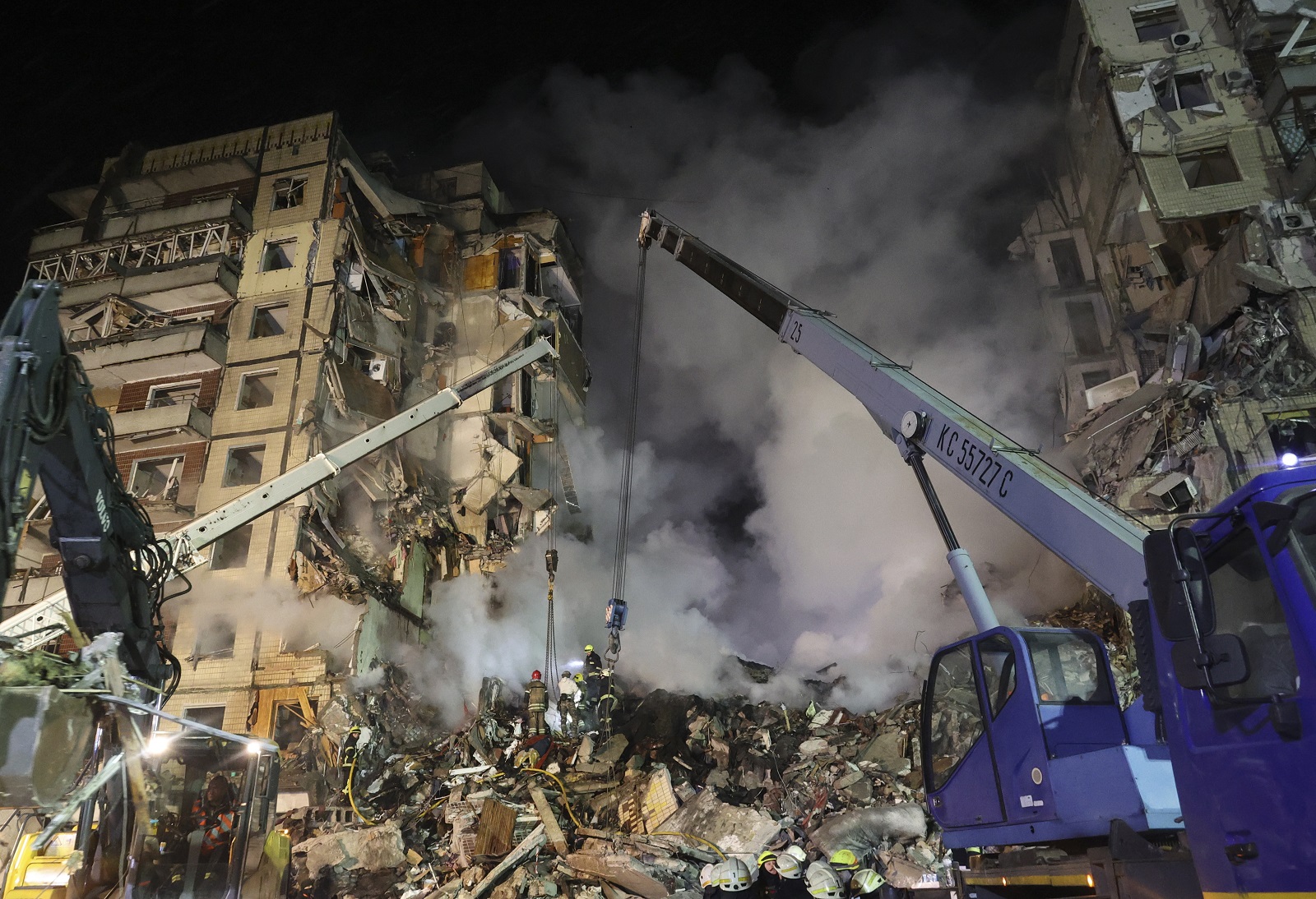 epa10406012 Rescue team work among the rubble of a damaged residential building hit by shelling in Dnipro, southeastern Ukraine, 14 January 2023, amid Russia's invasion. At least five people died and 64 others were injured, among them 14 children, after a rocket hit the nine-story building in Dnipro, the State Emergency Service (SES) of Ukraine reported on 14 January. Russian troops entered Ukraine on 24 February 2022 starting a conflict that has provoked destruction and a humanitarian crisis.  EPA/SERGEY KOZLOV