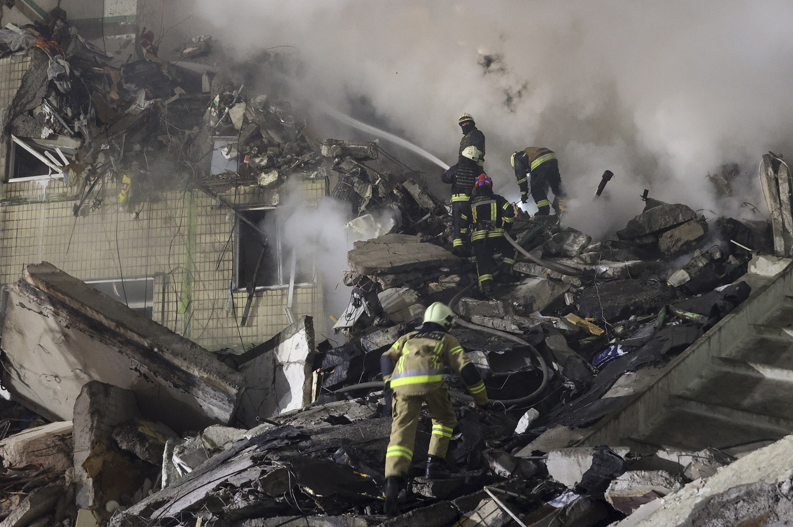 epa10406009 Rescue team work among the rubble of a damaged residential building hit by shelling in Dnipro, southeastern Ukraine, 14 January 2023, amid Russia's invasion. At least five people died and 64 others were injured, among them 14 children, after a rocket hit the nine-story building in Dnipro, the State Emergency Service (SES) of Ukraine reported on 14 January. Russian troops entered Ukraine on 24 February 2022 starting a conflict that has provoked destruction and a humanitarian crisis.  EPA/SERGEY KOZLOV