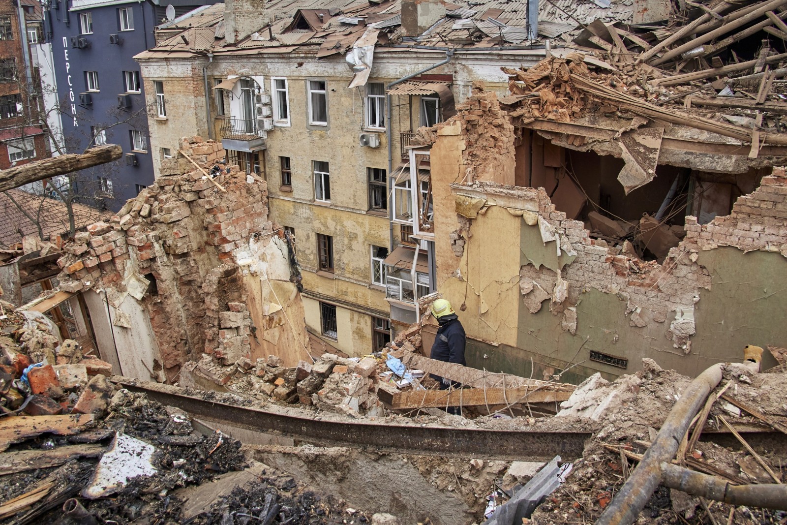 epa10439912 Ukrainian rescuers work on a residential building hit in Russian overnight shelling in Kharkiv, Ukraine, 30 January 2023. At least one woman was killed and three people were injured in the shelling, according to the Ukrainian Emergency Service. Kharkiv and surrounding areas have been the target of heavy shelling since February 2022, when Russian troops entered Ukraine territory starting an armed conflict that has provoked destruction and a humanitarian crisis.  EPA/SERGEY KOZLOV