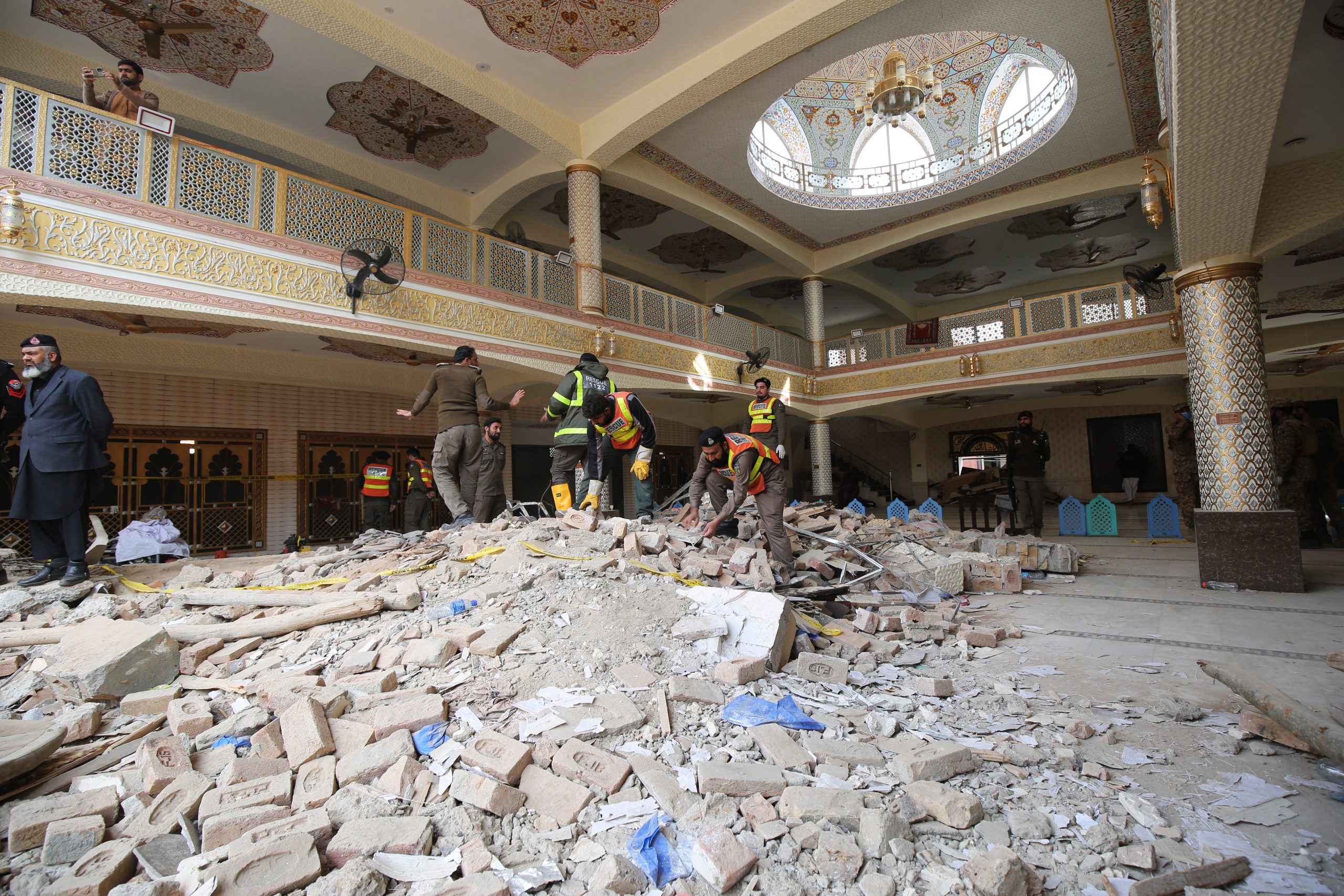 epa10440881 Rescue workers search for victims amid debris a day after a suicide bomb blast at a Mosque in Police Lines, in Peshawar, KPK province, Pakistan, 31 January 2023. The death toll from the suicide bombing has reached 92, police said on 31 January. Most of the deceased in the  attack, one of the deadliest ever staged on law enforcement authorities in Pakistan's history, are police and other members of the security forces.  EPA/ARSHAD ARBAB