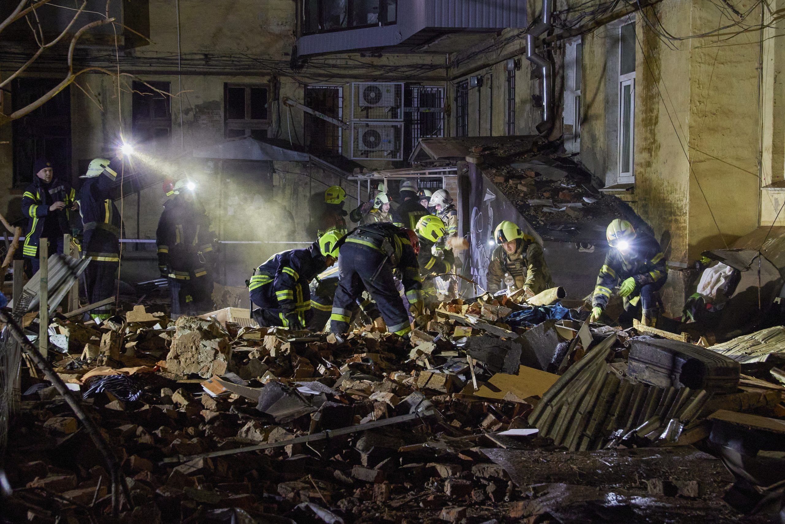 epa10439906 Ukrainian rescuers work on a residential building hit in Russian overnight shelling in Kharkiv, Ukraine, 30 January 2023. At least one woman was killed and three people were injured in the shelling, according to the Ukrainian Emergency Service. Kharkiv and surrounding areas have been the target of heavy shelling since February 2022, when Russian troops entered Ukraine territory starting an armed conflict that has provoked destruction and a humanitarian crisis.  EPA/SERGEY KOZLOV