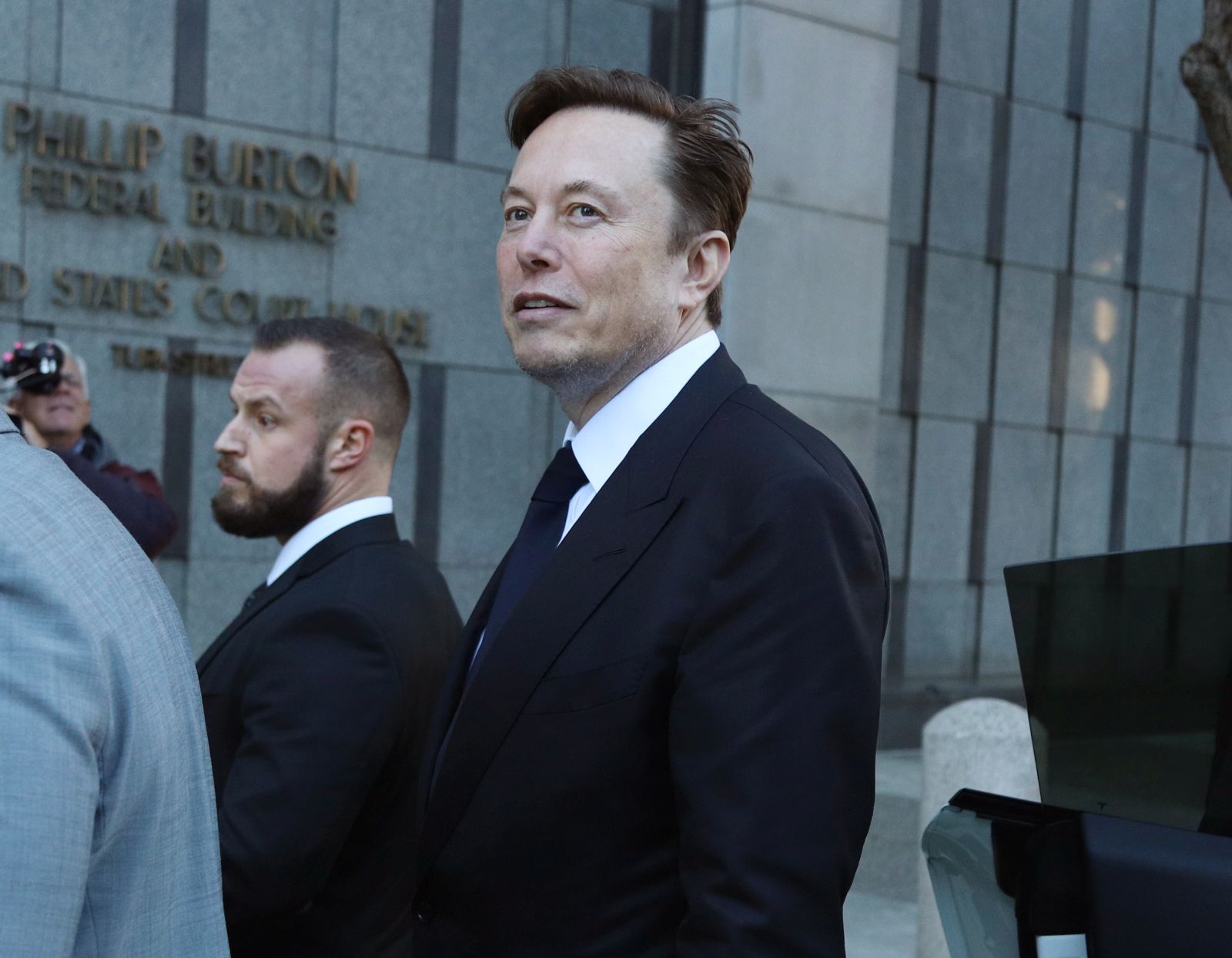 epa10427345 Tesla CEO Elon Musk (C) leaves the Phillip Burton Federal Building and U.S. Courthouse for the fourth day of the trial of Tesla shareholders lawsuit against Musk in San Francisco, California, USA, 24 January 2023. Tesla shareholders against CEO Elon Musk are taking him to court after he tweeted in 2018 that he could take Tesla private at 240 US dollars a share, a statement that caused volatility in the electric car company's stock price.  EPA/GEORGE NIKITIN