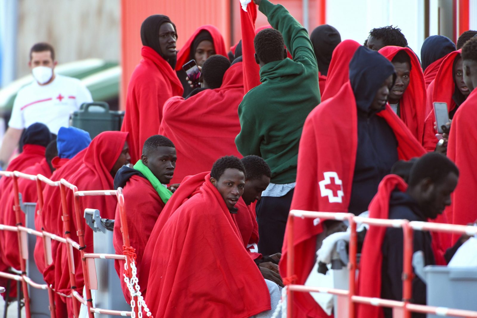 epa10440986 Several migrants rest at Gran Carajal port after their arrival on board a Spanish Sea Rescue Unit's ship in Gran Canaria island, southwestern Spain, 31 January 2023. Spanish authorities rescued some 171 migrant, including 14 women and four children, on board of three boats last night off southern Canary Islands coast.  EPA/Carlos de Saa