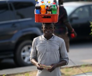 epa10446022 A man selling drinks in traffic holds the Nigeria naira currency notes along a road in Ikeja district of Lagos, Nigeria, 03 February 2023. The currency redesign policy by the Central Bank of Nigeria (CBN) aimed at checking counterfeiting and reducing the volume of money outside the banking system have come under public criticism, as the economy is cash crunched over the last week. The scarcity of the new redisgned currency have resulted in large crowds and long queues at cash points and banking halls in major cities across Nigeria.  EPA/Akintunde Akinleye