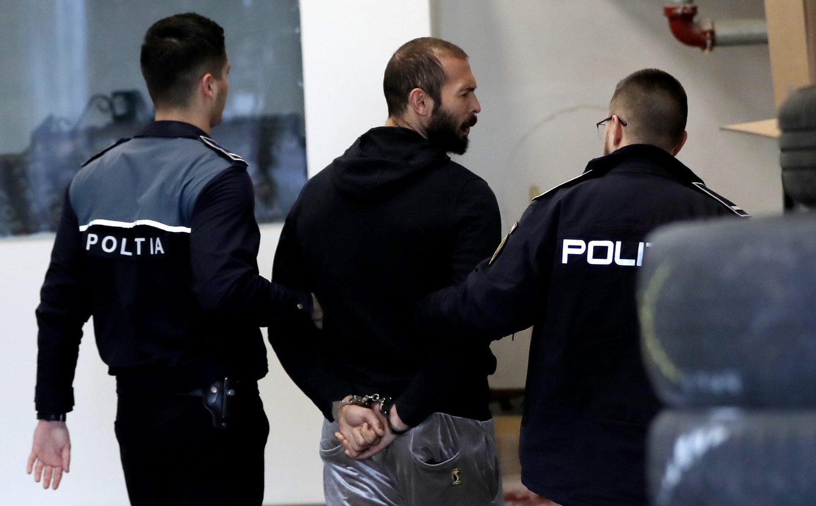 epa10464605 Former professional kickboxer and social media influencer Andrew Tate (C) is escorted by police officers to the Directorate for Investigating Organized Crime and Terrorism (DIICOT) headquarters to be questioned in Bucharest, Romania, 13 February 2023. On 29 December 2022, Andrew Tate and his brother Tristan were arrested as a result of the DIICOT inquiry under the charges of human trafficking and intention to form an organized crime group. Romanian police stated that the two brothers and their associates coerced victims for creating a paid pornography service for social media platforms.  EPA/ROBERT GHEMENT