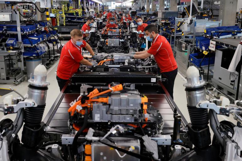epa08416438 Workers wearing protective face masks and gloves work in the production of the 'Taycan' electric sports cars at an assembly line of German car manufacturer Porsche in Stuttgart, Germany, 12 May 2020. Many companies are boosting their efforts to secure the health and safety of their employees following the resumption of work after shutting down production during the lockdown to stem the widespread of the SARS-CoV-2 coronavirus which causes the Covid-19 disease.  EPA-EFE/RONALD WITTEK